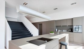 Mit Blick auf die besondere Treppe und eine moderne Küche