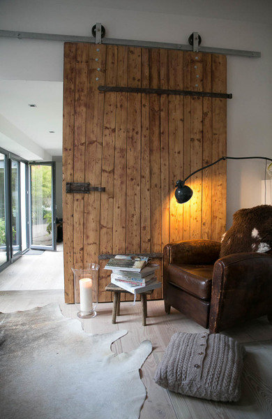 alter ledersessel vor scheunentor im wohnzimmer