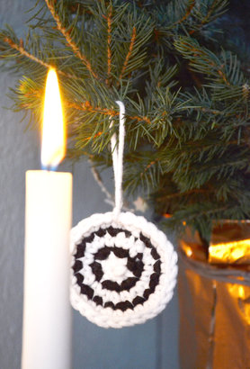 Kerzen mit gehäkeltem Baumschmuck
