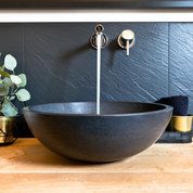 Modernes Basaltwaschbecken auf massiver Eichenholzplatte