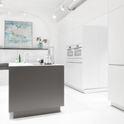 Geradlinige, moderne Küche mit farblich abgehobener Kücheninsel